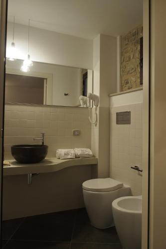 a bathroom with a sink and a toilet and a mirror at Terrazzani Suite in Comiso