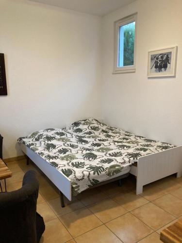 uma cama num quarto com um cobertor preto e branco em La Rosaire em Soulac-sur-Mer