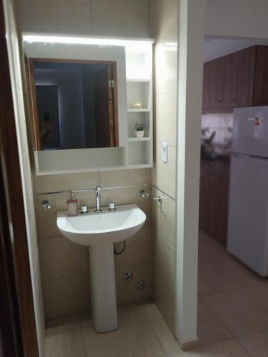 a bathroom with a sink and a mirror at Departamentos Iselin - Capo Bianco in San Rafael