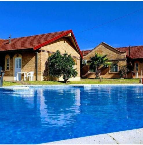 una casa con una piscina azul frente a una casa en Azahares del Ayuí en Concordia