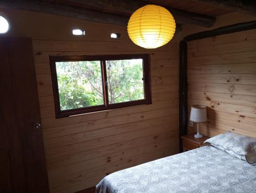 1 dormitorio con cama y ventana en Sietevestidos Casa Ecológica - Punta Negra, en Punta Colorada