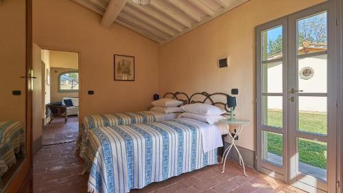 ein Schlafzimmer mit einem Bett mit einer blauen und weißen Decke in der Unterkunft Casa Campodonico 10 in Terranuova Bracciolini