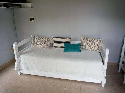 uma cama branca com duas almofadas num quarto em Azahares del Ayuí em Concordia