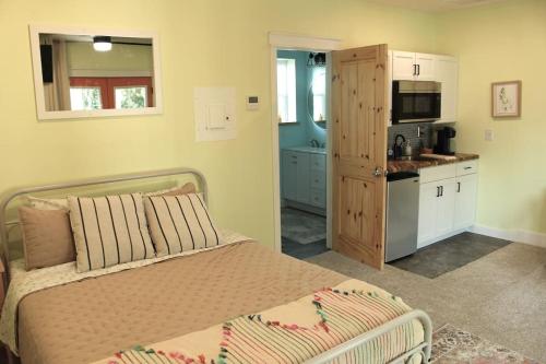 a bedroom with a bed and a small kitchen at Relax and Enjoy Bayou Grande in Pensacola