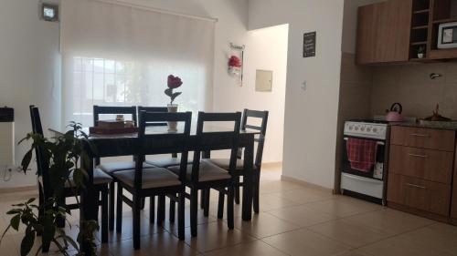 a kitchen with a table with chairs and a stove at Departamentos Iselin - Capo Bianco in San Rafael