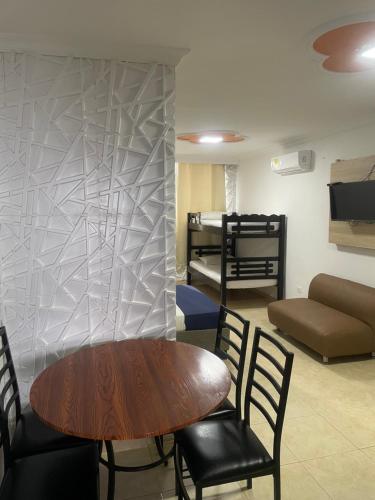um quarto com uma mesa e cadeiras e um sofá em Alojamientos Cartagena Edificio Los Delfines em Cartagena das Índias