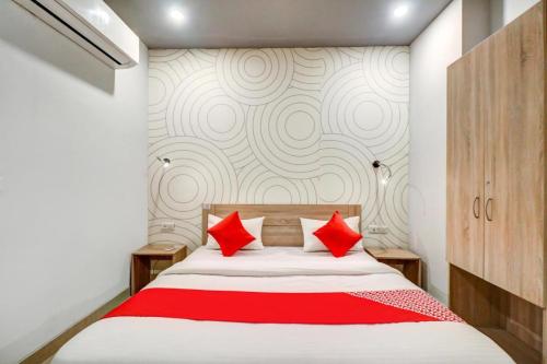 a bedroom with a large bed with red pillows at JPS DELIGHT HOTEL in New Delhi