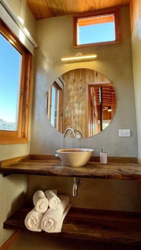a bathroom with a sink and a mirror and towels at El Pedregal - Casa Sur Solo Adultos in La Población