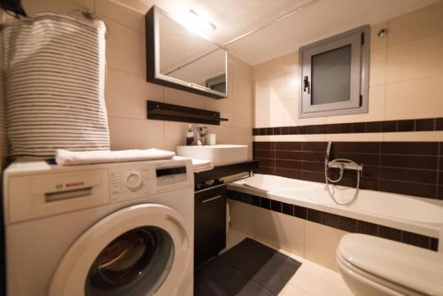 een badkamer met een wasmachine en een wastafel bij Chris & Mary comfort rooms Thessaloniki center in Thessaloniki