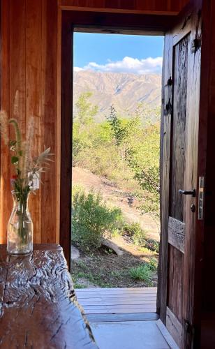 El Pedregal - Casa Norte Solo Adultos في La Población: باب لغرفة بها مزهرية على طاولة
