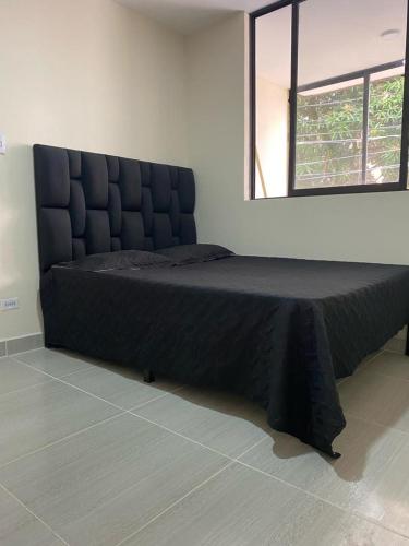 Hostel Medellin في ميديلين: سرير كبير في غرفة مع نافذة