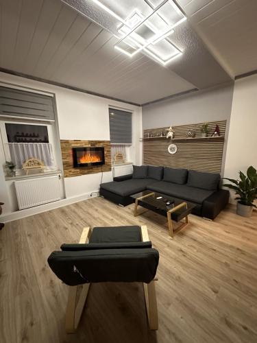 a living room with a black couch and a fireplace at FeWo BiBo in Freiberg