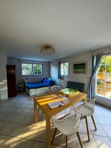 un salon avec une table, des chaises et un canapé dans l'établissement Studio Les Hortensias, à Arès