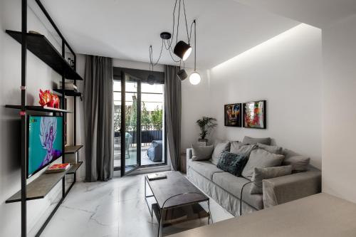 a living room with a couch and a tv at Downtown Boutique Apartments in Athens