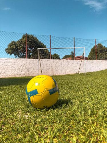 a yellow soccer ball sitting on the grass at Pousada Flores do Campo in Águas de Lindóia