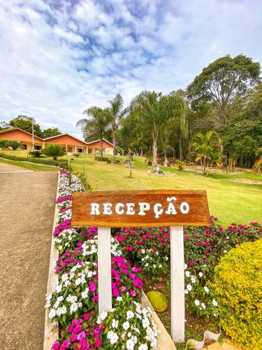 a sign in a park with flowers at Pousada Flores do Campo in Águas de Lindóia