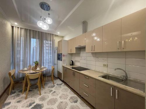 eine Küche mit einem Tisch und einem Esszimmer in der Unterkunft Уютная квартира в верхней части города in Almaty