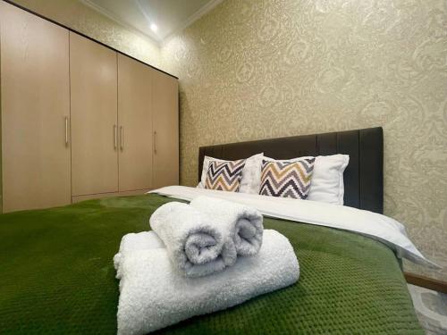 ein Schlafzimmer mit einem Bett mit Handtüchern darauf in der Unterkunft Уютная квартира в верхней части города in Almaty