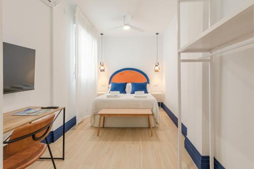 a bedroom with a bed with blue pillows at Indulge en Sevilla Faustino 45 in Seville
