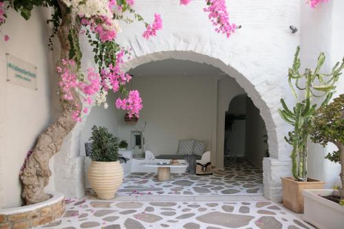 a courtyard with pink flowers in a building at Iria Beach Art Hotel in Agia Anna Naxos