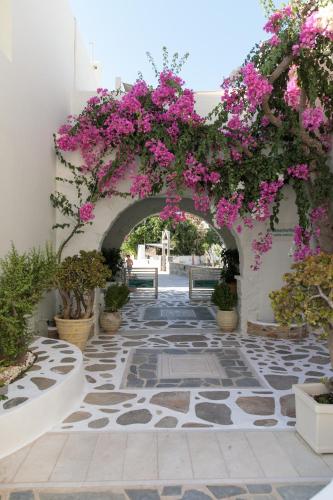 a walkway with pink flowers on a building at Iria Beach Art Hotel in Agia Anna Naxos