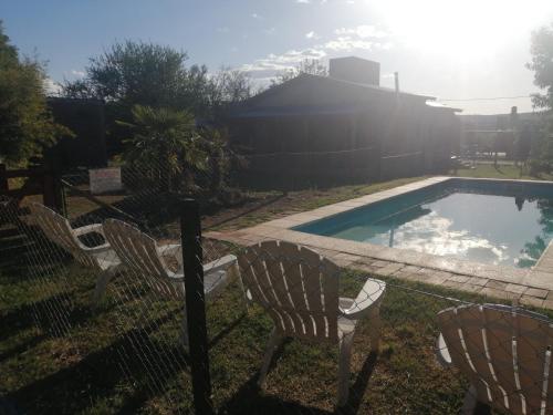 um quintal com duas cadeiras e uma piscina em Azul em Arroyo de Los Patos