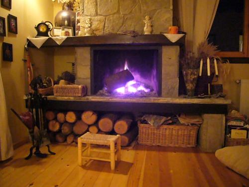 a living room with a fire in a fireplace at Port del Comte a pie de pistas in La Coma i la Pedra