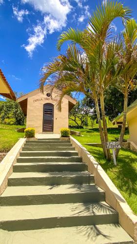 a staircase leading to a building with a palm tree at Pousada Flores do Campo in Águas de Lindóia