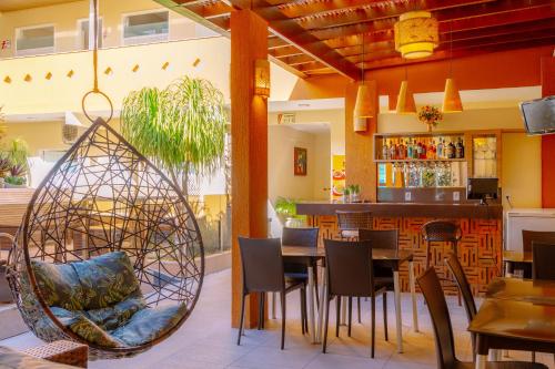 a restaurant with a table and chairs and a bar at Rede Andrade Terra Brasil in Porto Seguro