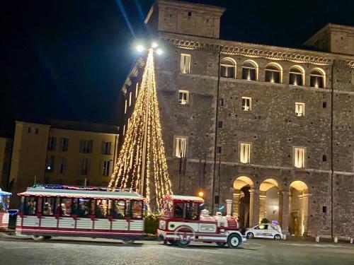 a christmas tree in front of a building with a trolley at Bilocale degli Innamorati in Terni