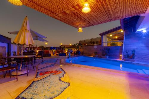a swimming pool with a table and an umbrella at Rede Andrade Terra Brasil in Porto Seguro