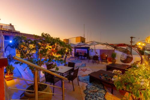 a rooftop patio with tables and chairs and plants at Rede Andrade Terra Brasil in Porto Seguro