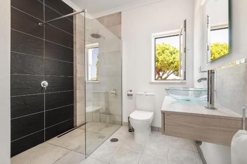 een badkamer met een toilet en een glazen douche bij Villa Cambria by OCvillas in Albufeira