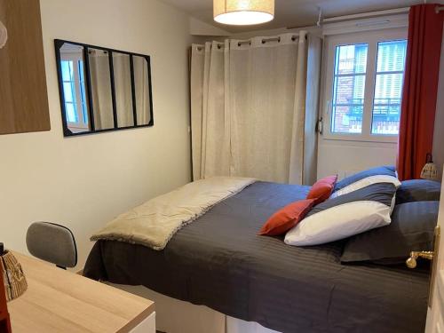 a bedroom with a bed with pillows and a window at Cosy Logis en hyper-centre in Le Mans