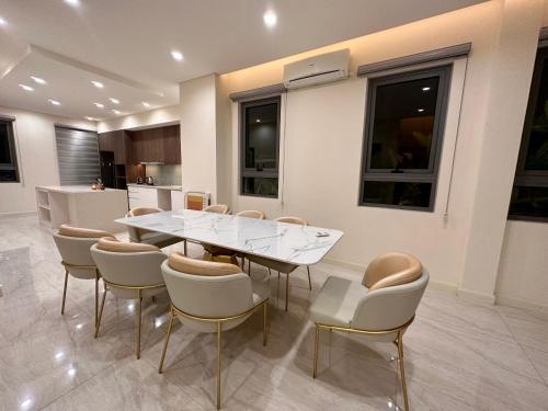 a dining room with a white table and chairs at Shine HolliDay Villa HaNoi in Hanoi