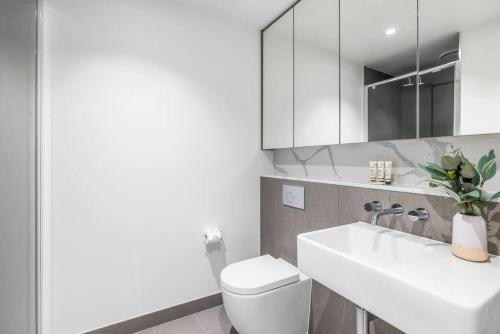 La salle de bains est pourvue de toilettes, d'un lavabo et d'un miroir. dans l'établissement Stunning Southbank 1 bed Free Parking, à Melbourne
