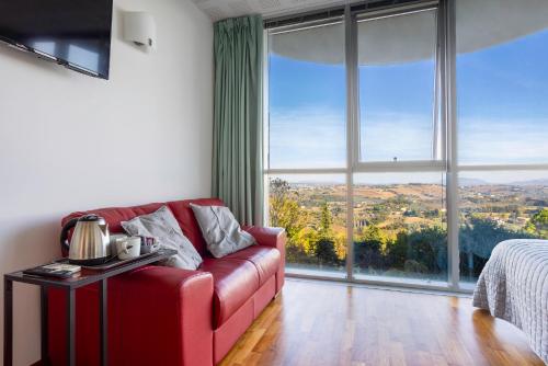 a living room with a red couch and a large window at Lo Spettacolo in Macerata