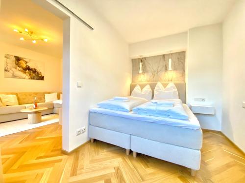 Un dormitorio con una cama y una sala de estar. en Best Butler Apartments Golden Glory I Zentrum I Küche I Parken I Netflix, en Füssen