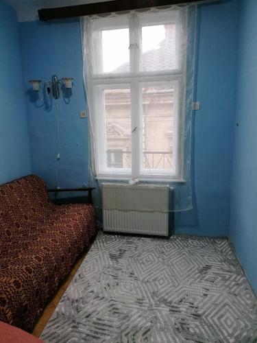 Camera blu con letto e finestra di Apartament 2 camere a Braşov