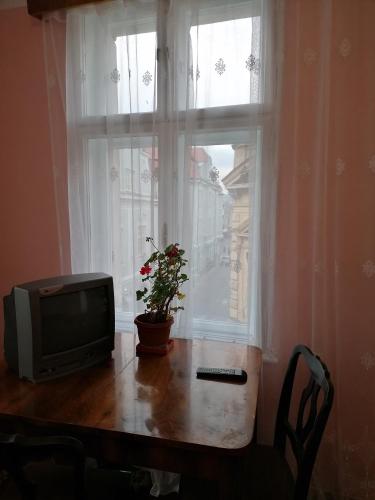 una televisione seduta su un tavolo di fronte a una finestra di Apartament 2 camere a Braşov