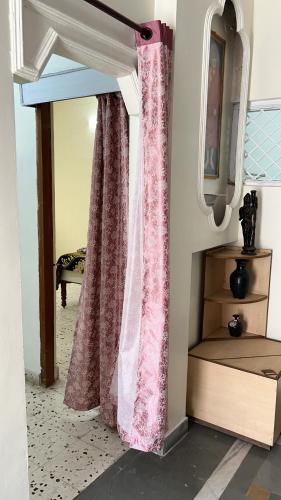 a curtain in a room with a bed and a mirror at Chandrajyoti Villa 2 Garden Facing. in Nagpur