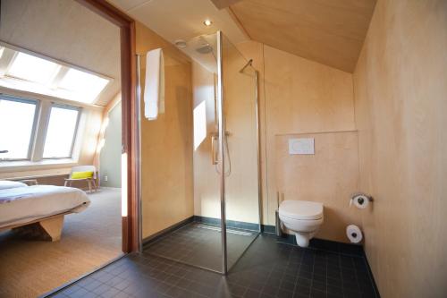 Bed & Coffee Skilleplaatsje في دن بورخ: حمام مع دش ومرحاض في الغرفة
