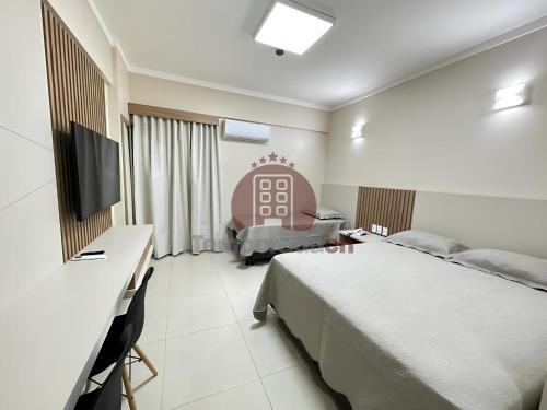 a bedroom with a bed and a desk and a tv at Spazzio DiRoma Parks in Caldas Novas