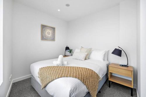 een slaapkamer met een wit bed en een nachtkastje bij Stunning Stature Southbank 1 bed in Melbourne