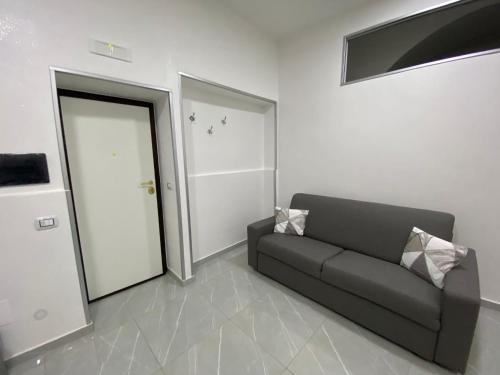un soggiorno con divano di fronte a una porta di Le 3 Sorelle House a Napoli
