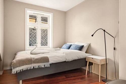 een slaapkamer met een bed en een raam bij Dinbnb Apartments I The Bryggen Experience I Enjoy Life with Friends & Family in Bergen