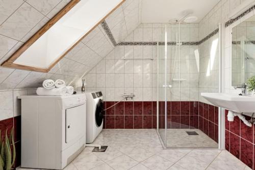 een badkamer met een wasmachine en een wastafel bij Dinbnb Apartments I The Bryggen Experience I Enjoy Life with Friends & Family in Bergen