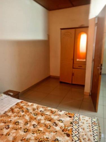 Schlafzimmer mit einem Bett, einem Fenster und einer Tür in der Unterkunft YILIMDE APPARTEMENTS in Ouagadougou
