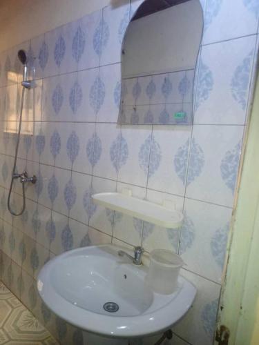 a bathroom with a white sink and a mirror at YILIMDE APPARTEMENTS in Ouagadougou