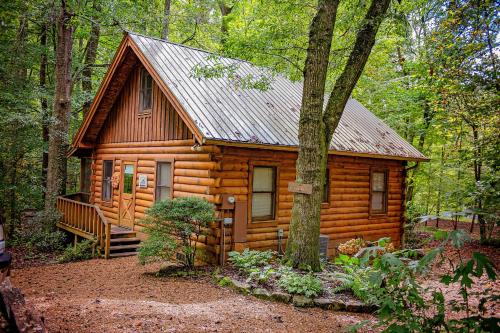 a log cabin in the woods with a tree at Creek Crest Cabin Ocoee Riverside Cabin in Ocoee